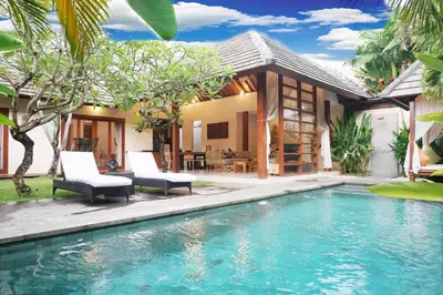 a villa with a swimming pool in front of a house at Nil Villa Seminyak in Seminyak