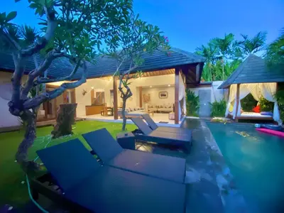 a backyard with a swimming pool and a house at Nil Villa Seminyak in Seminyak