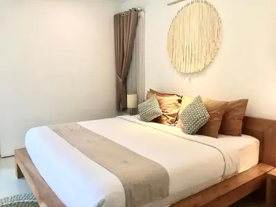 a bedroom with a large bed with brown pillows at Nil Villa Seminyak in Seminyak