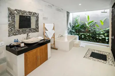 a bathroom with a sink and a tub and a mirror at Sandi Agung Villa Bidadari in Seminyak