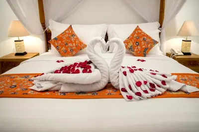 two swans made out of towels on a bed at Sandi Agung Villa Bidadari in Seminyak