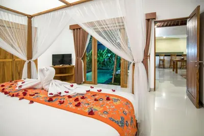 a bedroom with a bed with flowers on it at Sandi Agung Villa Bidadari in Seminyak