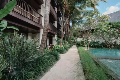 a path in front of a building with a swimming pool at Ramayana Suites and Resort in Kuta