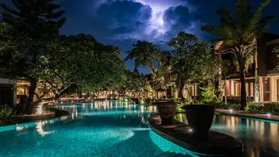 a swimming pool in a resort at night at Ramayana Suites and Resort in Kuta