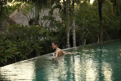 a man in a swimming pool in a resort at The Kayana in Seminyak