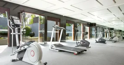 a gym with several treadms and cardio machines at The Kayana in Seminyak