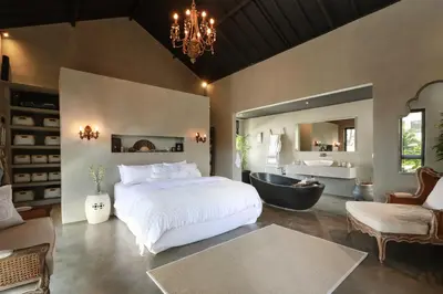 a bedroom with a large bed and a bath tub at Villa Suku Berawa in Canggu