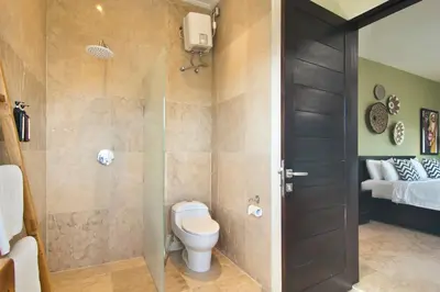 a bathroom with a toilet and a walk in shower at Villa Uma Sari - 2BDR, Private Pool and Sunset Rooftop, Quiet and Central in Seminyak