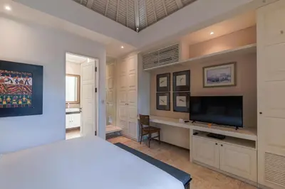 a bedroom with a bed and a desk and a television at Mosan House - unique art-filled gem in perfect location a short walk from the beach or Seminyak Square including AC office for remote working in Seminyak
