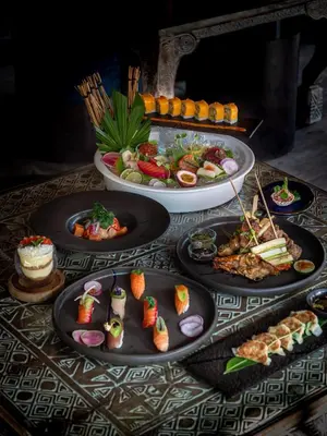 a table with several plates of food on it at Blue Karma Village in Seminyak