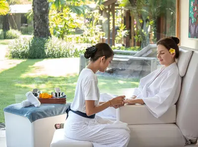 two women in white robes sitting on a couch at Blue Karma Village in Seminyak