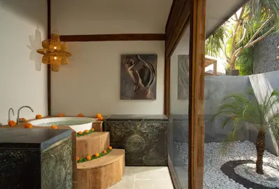 a bathroom with a tub and a potted plant at Blue Karma Village in Seminyak