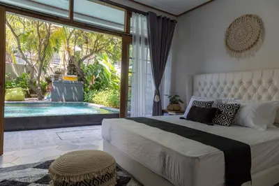 a bedroom with a large bed and a swimming pool at Interconnection Hostel in Kuta