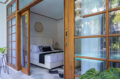 a bedroom with a bed and a glass door at Interconnection Hostel in Kuta