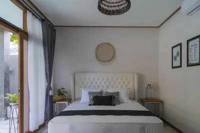 a bedroom with a large white bed with two pillows at Interconnection Hostel in Kuta