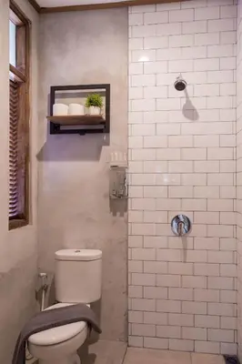 a bathroom with a white toilet and a shower at Interconnection Hostel in Kuta