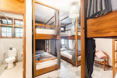 two bunk beds in a room with a toilet at Interconnection Hostel in Kuta