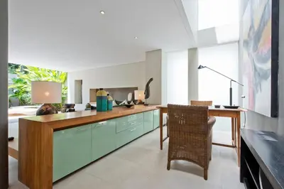 a kitchen with blue cabinets and a table and chairs at VILLA OLYMPIA in Seminyak