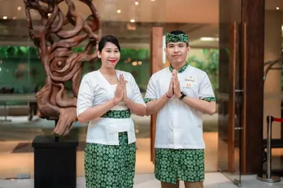 a man and a woman are doing a gesture at Swiss-Belhotel Rainforest in Kuta