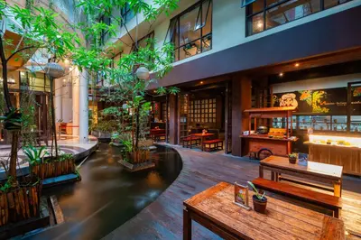 a lobby with benches and plants in a building at Swiss-Belhotel Rainforest in Kuta