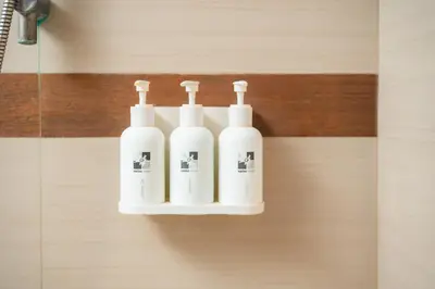 a group of four white soap dispensers on a wall at Swiss-Belhotel Rainforest in Kuta