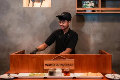 a man standing behind a counter in a kitchen at Swiss-Belhotel Rainforest in Kuta