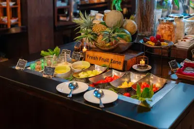 a buffet with fruits and vegetables on a table at Swiss-Belhotel Rainforest in Kuta