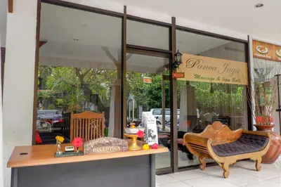 a store front with a table and a chair in front at Puri Panca Jaya Hotel in Seminyak