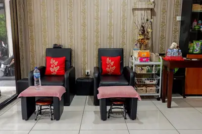 two black chairs with red pillows in a store at Puri Panca Jaya Hotel in Seminyak