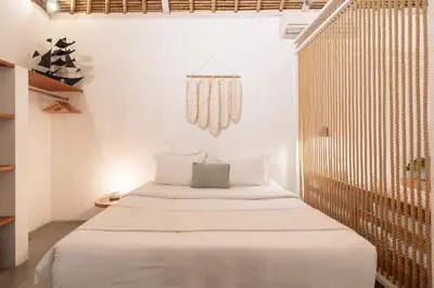 a bedroom with a large bed with white sheets at House of Bagera by Alfred in Bali in Seminyak