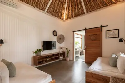 a room with two beds and a tv and a door at House of Bagera by Alfred in Bali in Seminyak