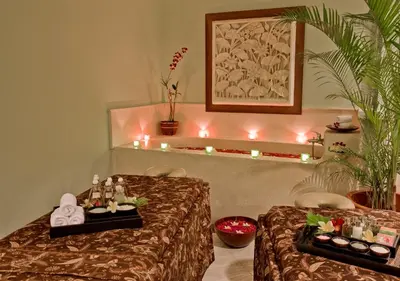 a massage room with two beds with candles on it at Bali Rani Hotel in Kuta