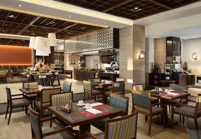 a restaurant with tables and chairs and a kitchen at Conrad Bali in Nusa Dua