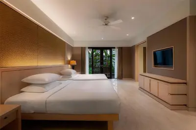 a bedroom with two beds and a flat screen tv at Conrad Bali in Nusa Dua
