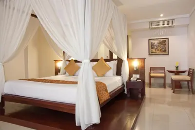 a bedroom with a bed with a canopy at The Rani Hotel & Spa in Kuta