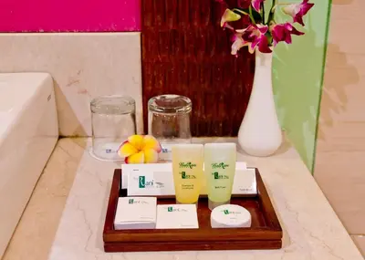 a tray with three candles and a vase with flowers at The Rani Hotel & Spa in Kuta