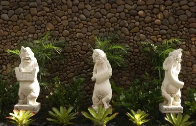 four white statues standing in front of a wall at Lumbini Luxury Villas and Spa in Jimbaran