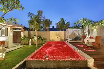 a garden with a large red pond in front of a house at Lumbini Luxury Villas and Spa in Jimbaran
