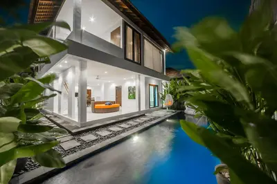 a villa with a swimming pool at night at Villa Pearl Seminyak in Seminyak