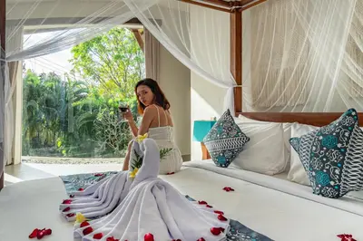 a woman sitting on a bed in a room at Luxury - Villa K - Central Seminyak in Seminyak