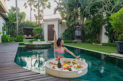 a woman in a swimming pool with a bowl of food at Luxury - Villa K - Central Seminyak in Seminyak