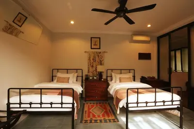 a bedroom with two beds and a ceiling fan at Brown Feather Batu Belig in Seminyak