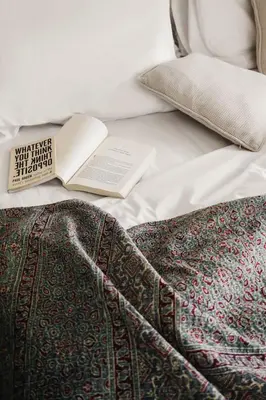 a book sitting on top of a bed with a blanket at Brown Feather Batu Belig in Seminyak
