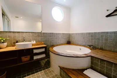 a bathroom with a tub and a sink at Brown Feather Batu Belig in Seminyak