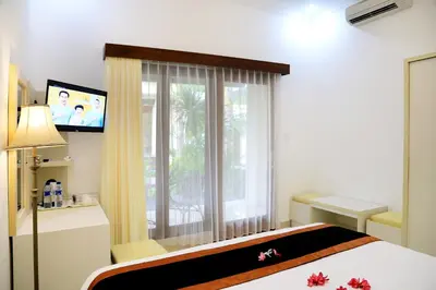 a bedroom with a bed and a tv and a window at Kaniya bali in Nusa Dua