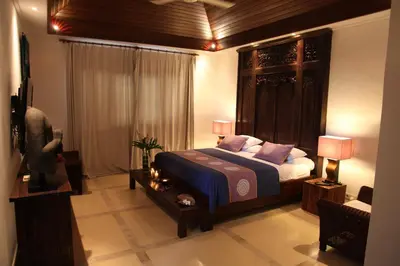 a bedroom with a bed with a wooden headboard at Villa Casa Bali - your home away from home in Seminyak