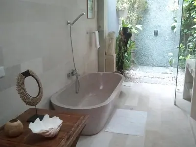 a bathroom with a bath tub and a table at Villa Casa Bali - your home away from home in Seminyak