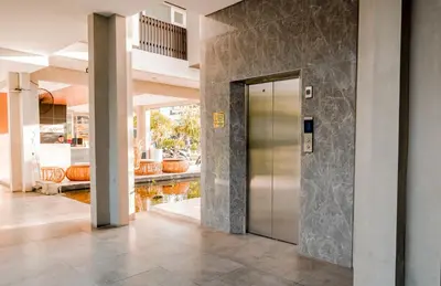 a lobby with a metal elevator in a building at The Rooms Apartment Bali by ARM Hospitality in Denpasar