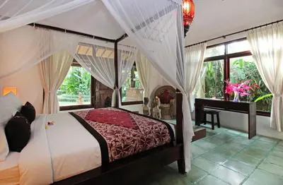 a bedroom with a canopy bed and a desk at Villa Jumah in Seminyak