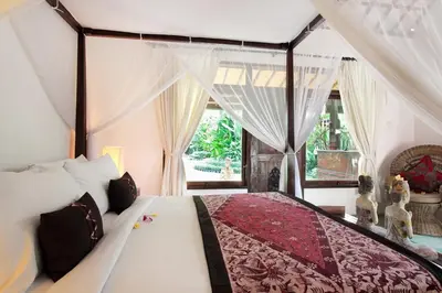 a bedroom with a large bed with a canopy at Villa Jumah in Seminyak